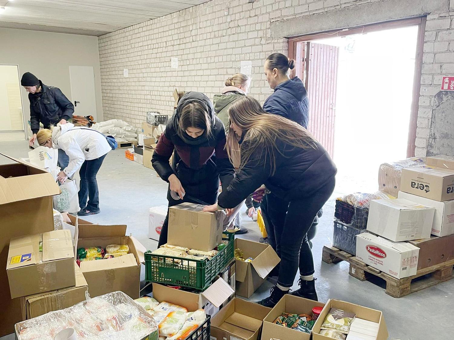 Iškeliavo trečioji paramos siunta Ukrainai / Ukmergiškių aukotas prekes padeda pakuoti savanoriai.